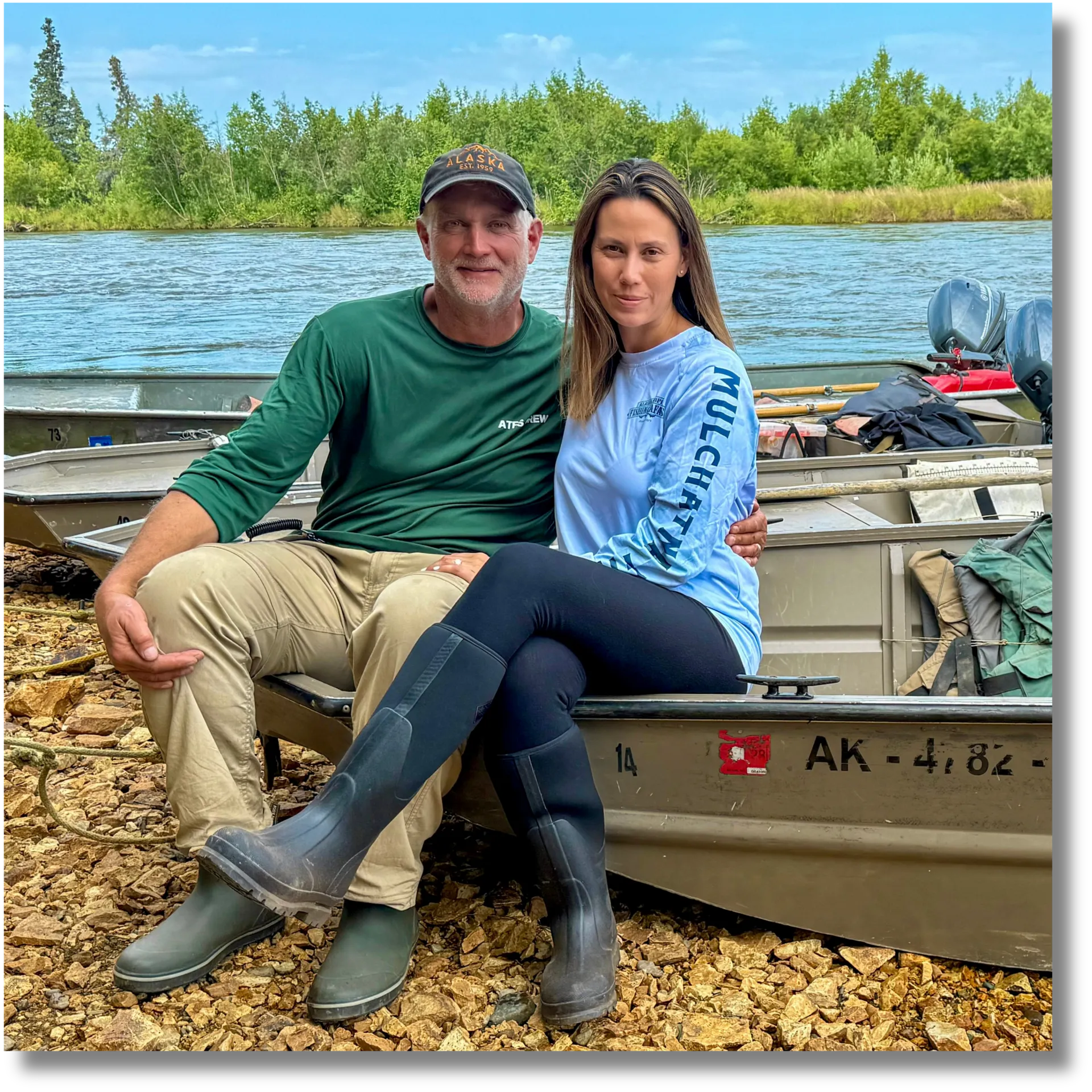 Doug and Kim Mostrom seated beside a boat on the Mulchatna River